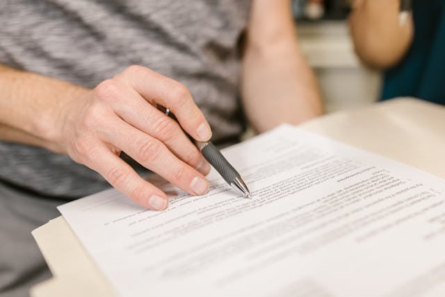 hand holding pen on white paper